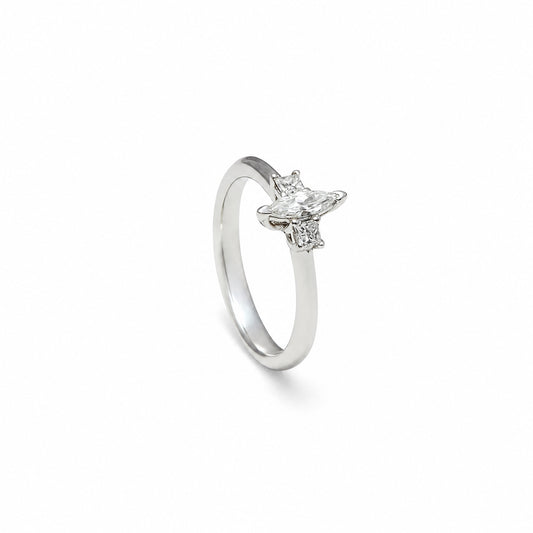 Anillo de compromiso con centro luminoso. La piedra central se eleva sobre una montura de garras visibles.