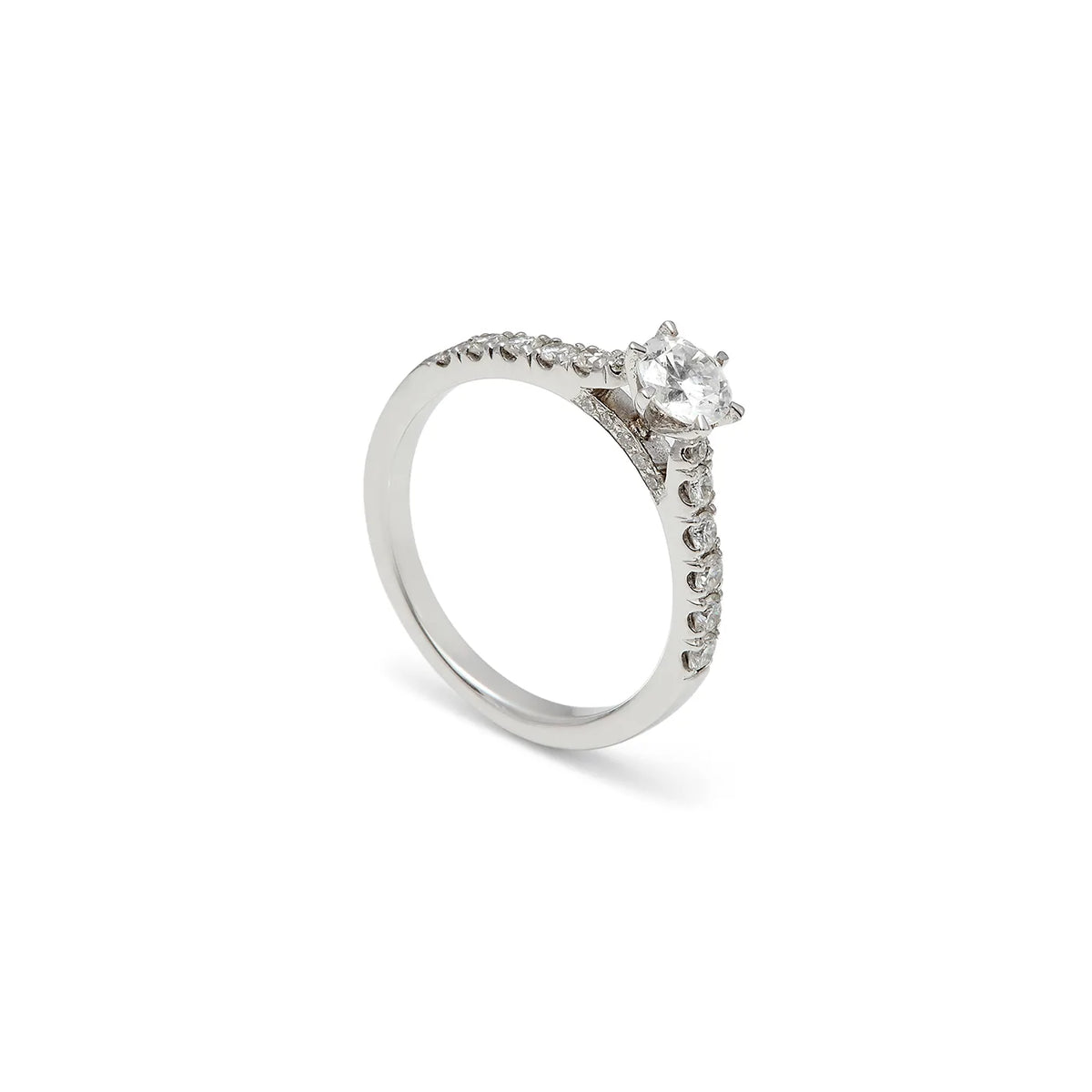 Anillo de compromiso con hombros luminosos. Las pequeñas piedras siguen la parte superior de la banda.