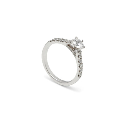 Anillo de compromiso con hombros luminosos. Las pequeñas piedras siguen la parte superior de la banda.