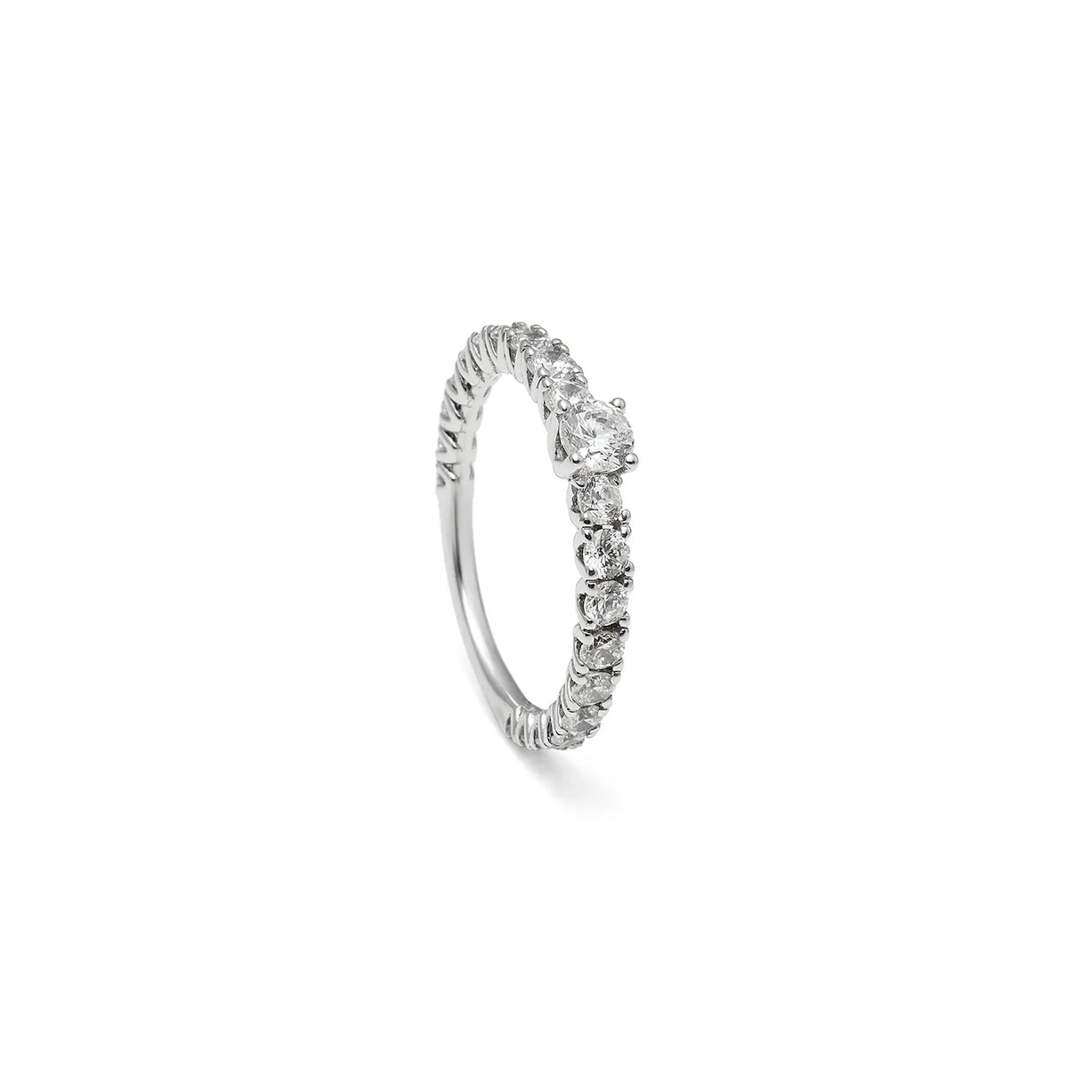 Anillo de compromiso de contorno luminoso. Las piedras incoloras se suceden en el tramo visible del aro.