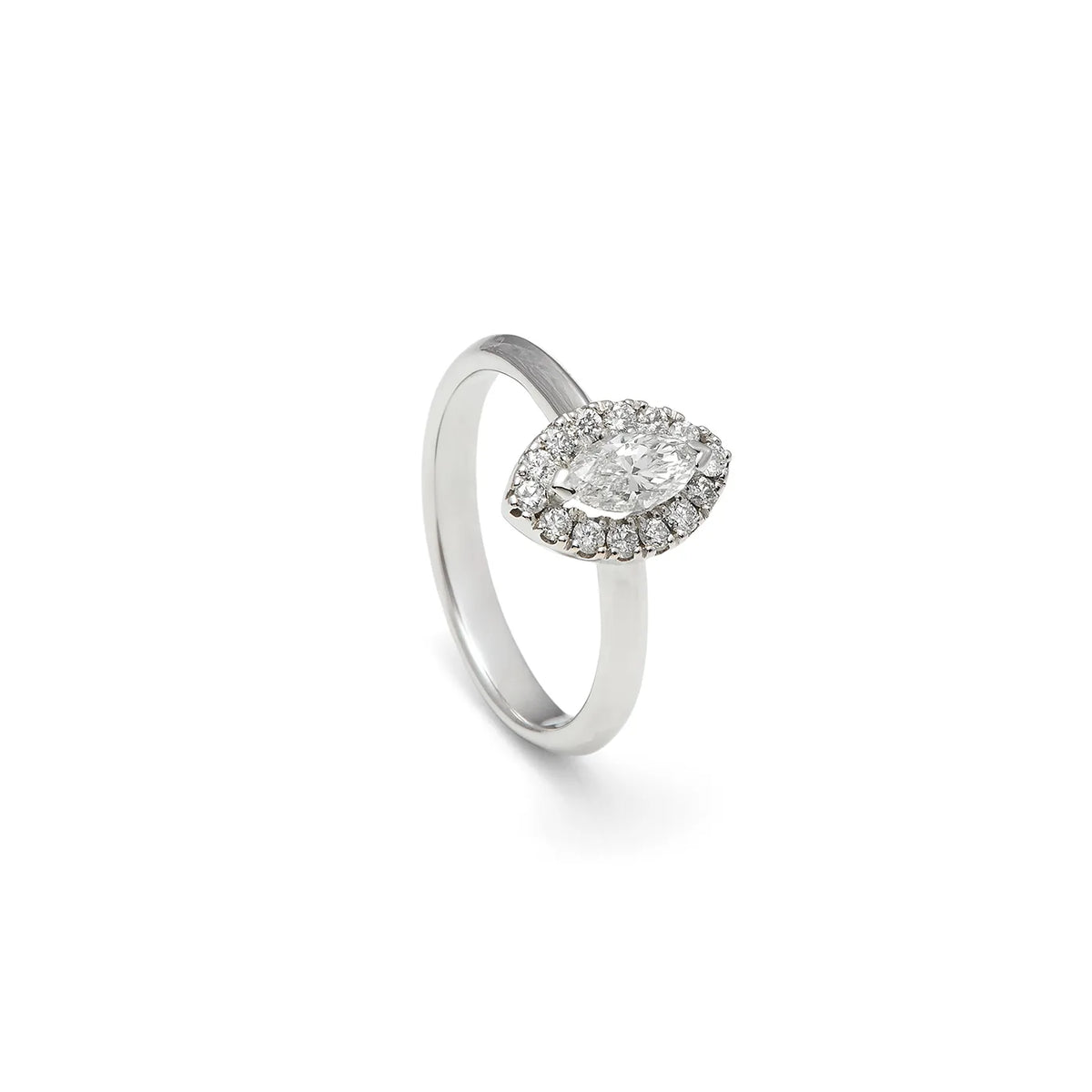 Anillo de compromiso con frente ovalado. Una orla de pequeñas piedras perfila el centro del diseño.