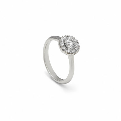Anillo rosetón de aro liso. El centro incoloro queda rodeado por pequeñas piedras luminosas.