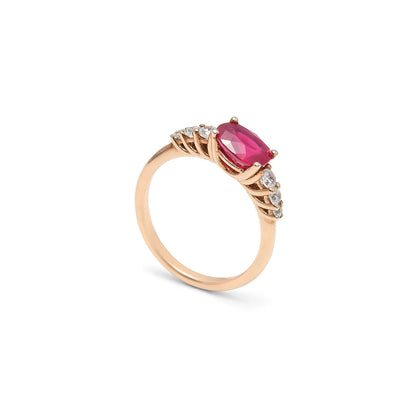 Anillo de centro rosado y hombros de luz. Las garras visibles enmarcan la piedra alargada del frente.