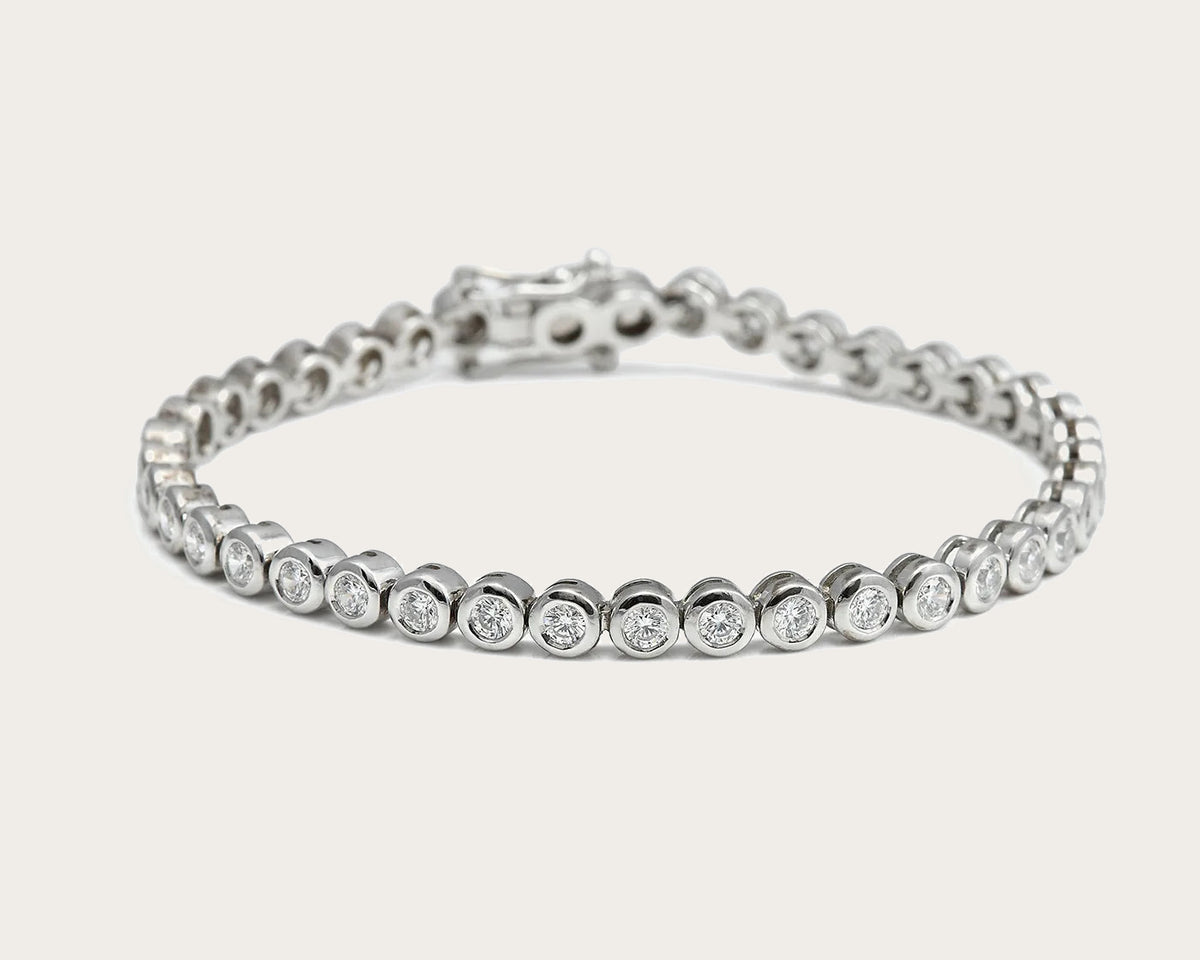Pulsera rivière de centros redondos. Los bordes de tono plateado enmarcan cada piedra incolora.