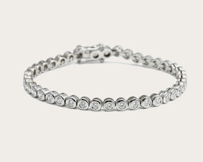 Pulsera rivière de centros redondos. Los bordes de tono plateado enmarcan cada piedra incolora.