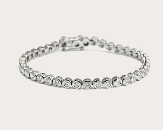 Pulsera rivière de centros redondos. Los bordes de tono plateado enmarcan cada piedra incolora.