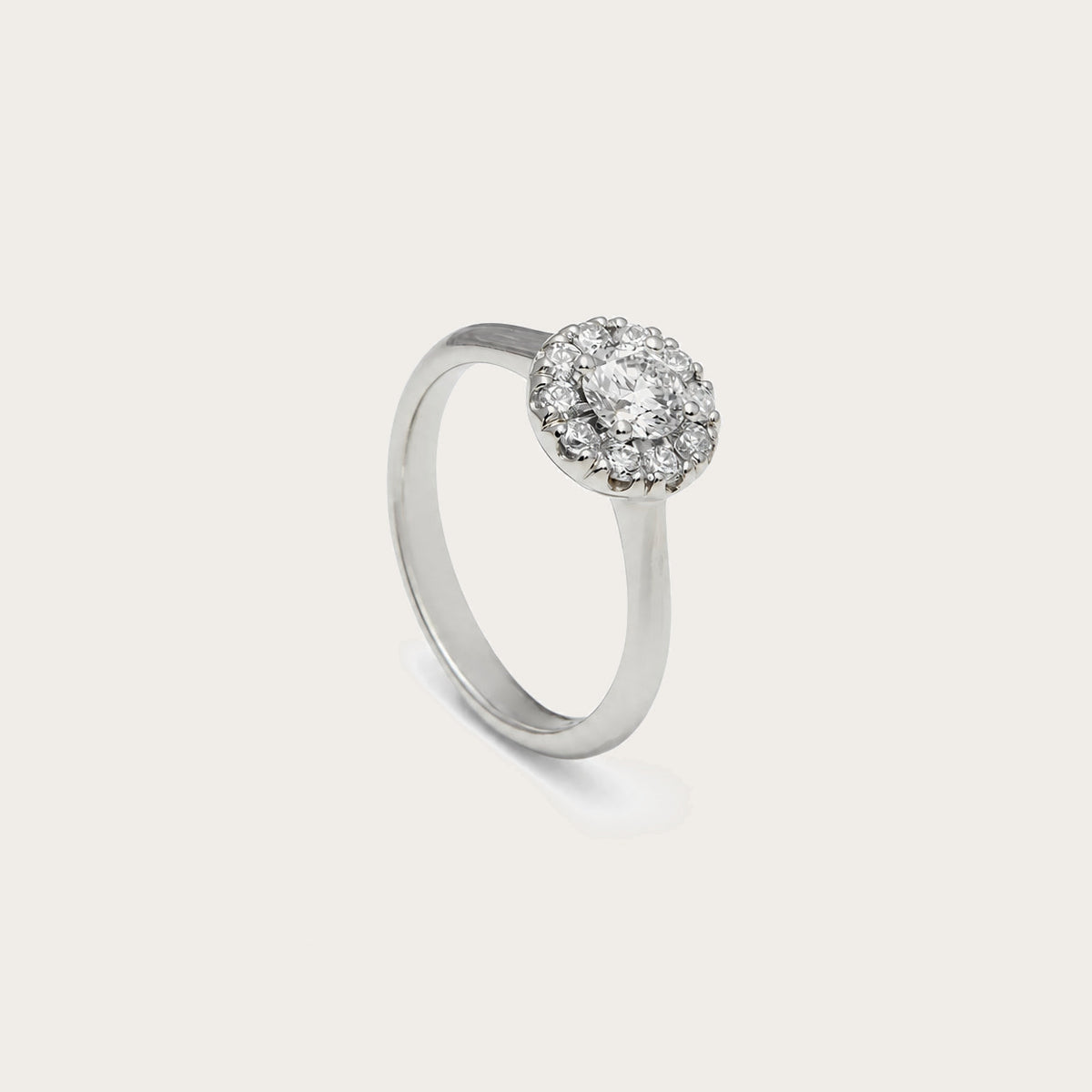 Anillo rosetón de aro liso. El centro incoloro queda rodeado por pequeñas piedras luminosas.