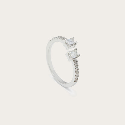 Anillo abierto con centros rectangulares. Las dos monturas aparecen a distinta altura en la composición.