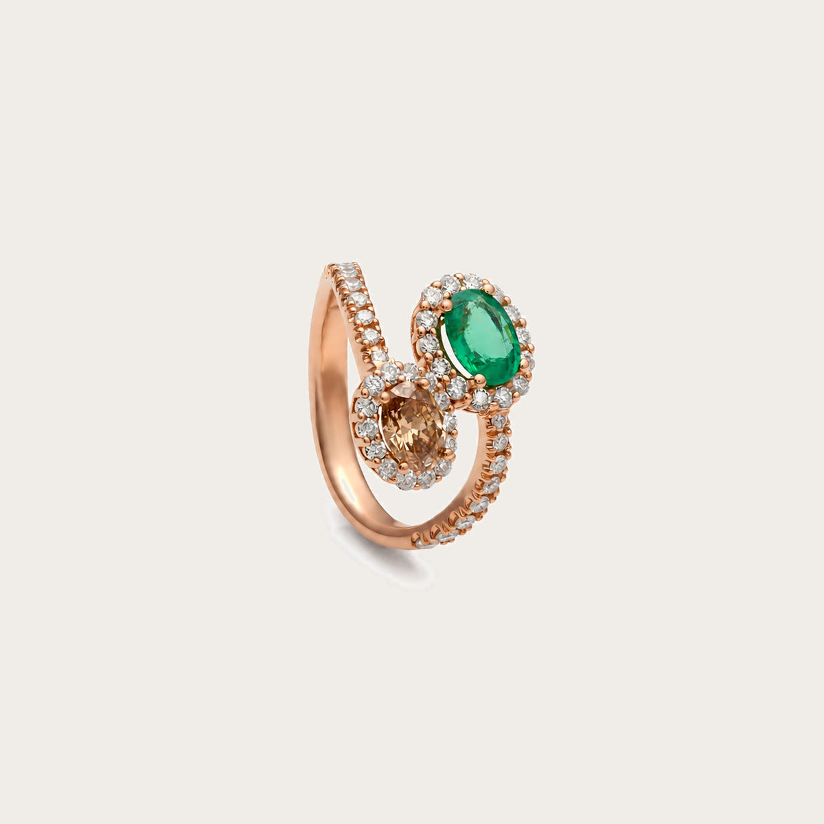 Anillo abierto de esmeralda y diamante oval. Las bandas se desdoblan para enmarcar los centros a distinta altura.