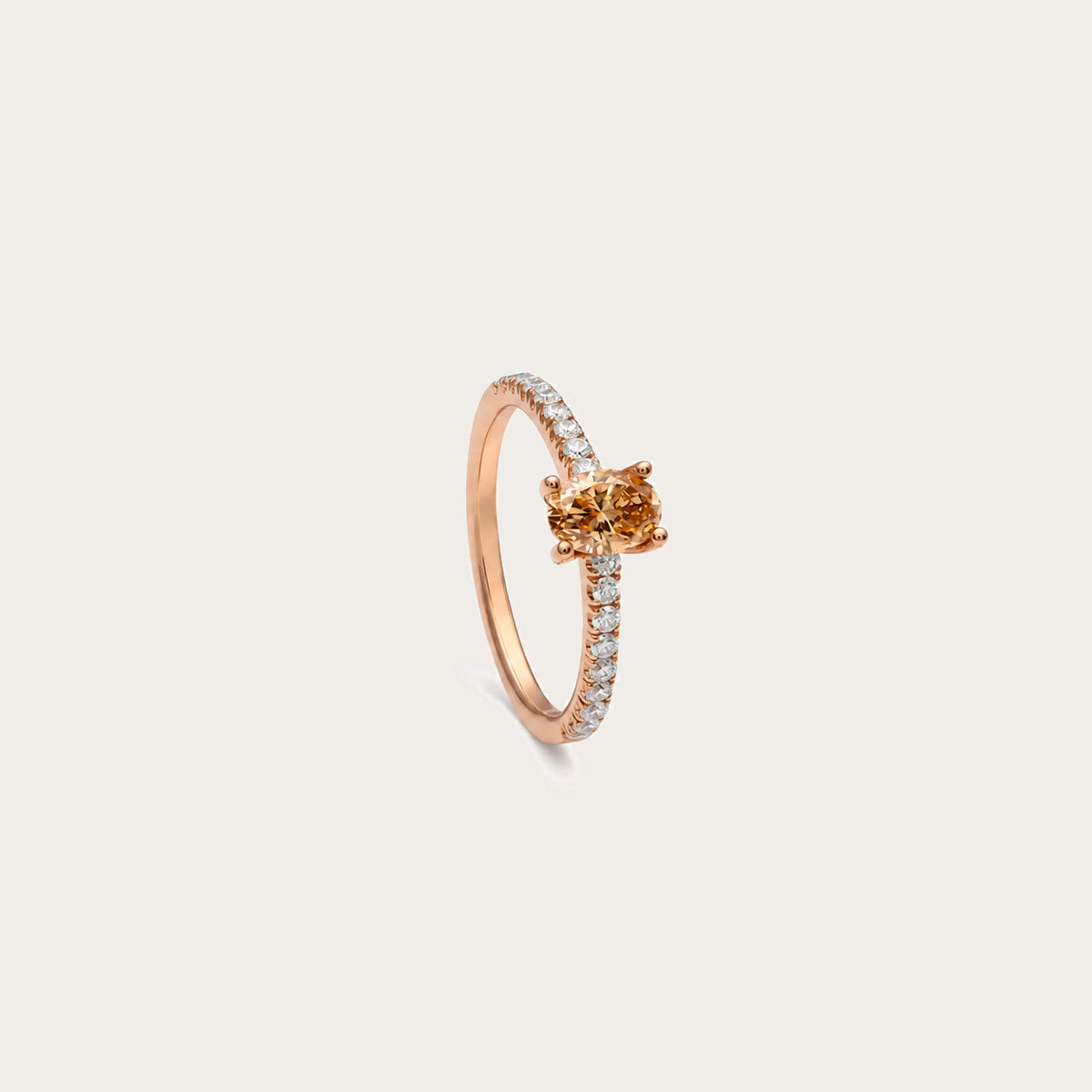 Anillo de diamante oval color coñac. La montura central presenta garras visibles alrededor del contorno ovalado.
