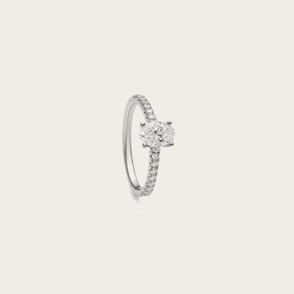 Anillo de diamante oval y brillantes. La montura de garras deja visible el contorno ovalado del centro.