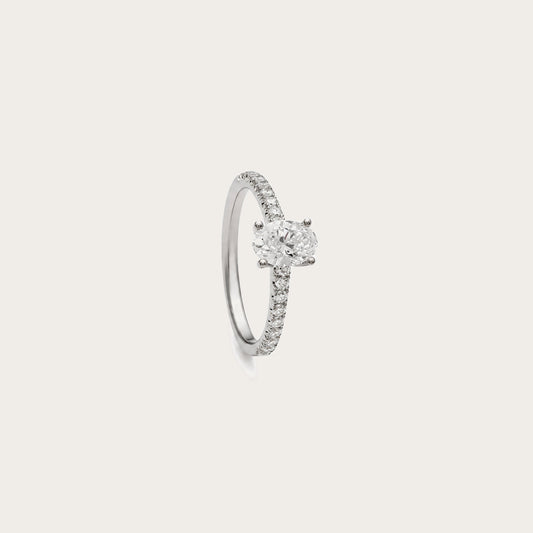 Anillo de diamante oval y brillantes. La montura de garras deja visible el contorno ovalado del centro.