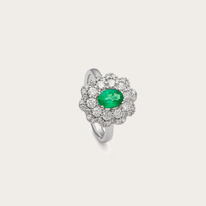 Anillo de esmeralda oval y rosetón. Los brillantes se agrupan alrededor del centro como pequeños pétalos luminosos.