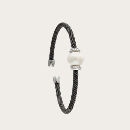 Pulsera de acero con centro nacarado. El detalle redondo queda entre dos bandas decorativas de tono plateado.