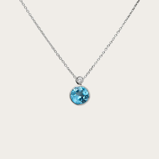 Colgante de centro azul redondo. El borde de tono plateado perfila la piedra azul.