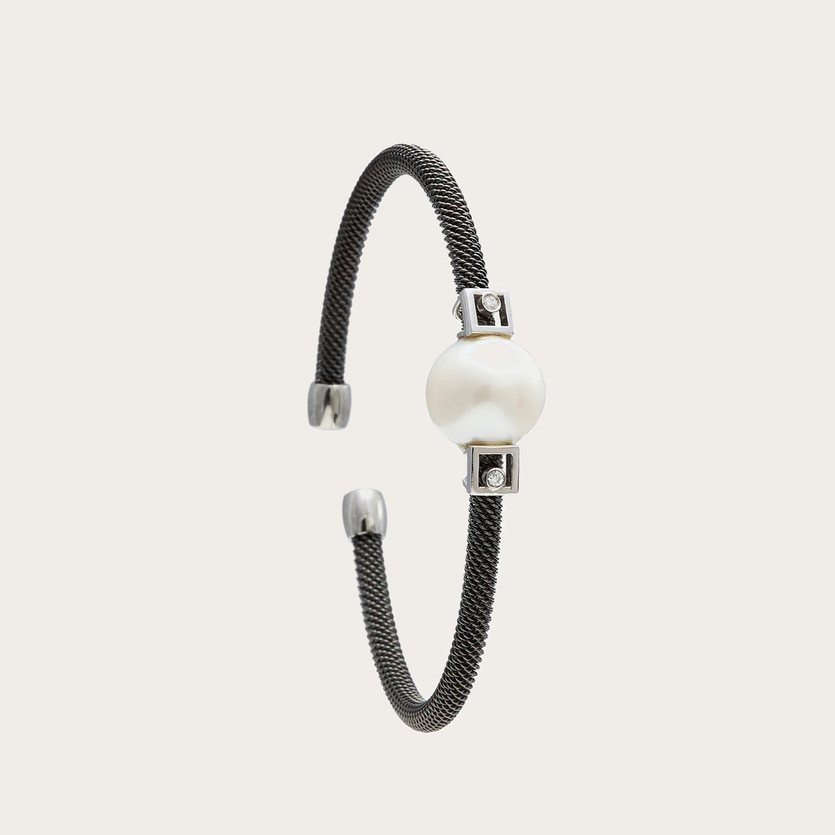 Pulsera de acero y detalles geométricos. Las pequeñas formas rectangulares delimitan el motivo redondo.