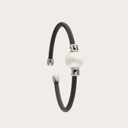 Pulsera de acero y detalles geométricos. Las pequeñas formas rectangulares delimitan el motivo redondo.