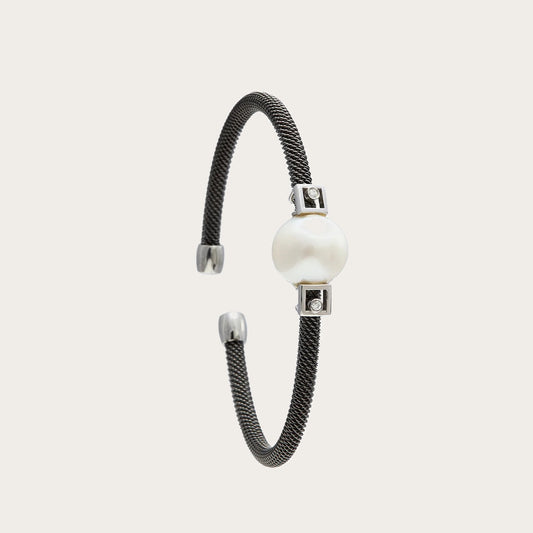 Pulsera de acero y detalles geométricos. Las pequeñas formas rectangulares delimitan el motivo redondo.