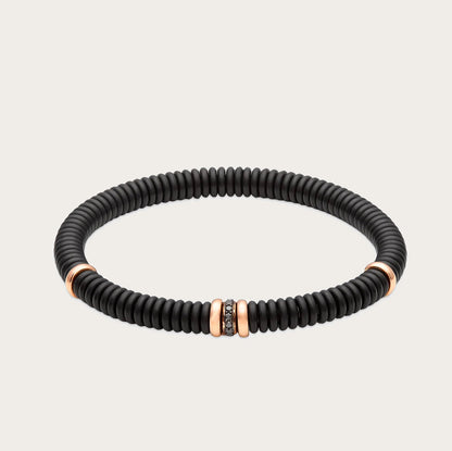 Pulsera oscura con brillantes negros. El aro muestra un relieve de líneas repetidas.