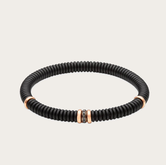 Pulsera oscura con brillantes negros. El aro muestra un relieve de líneas repetidas.