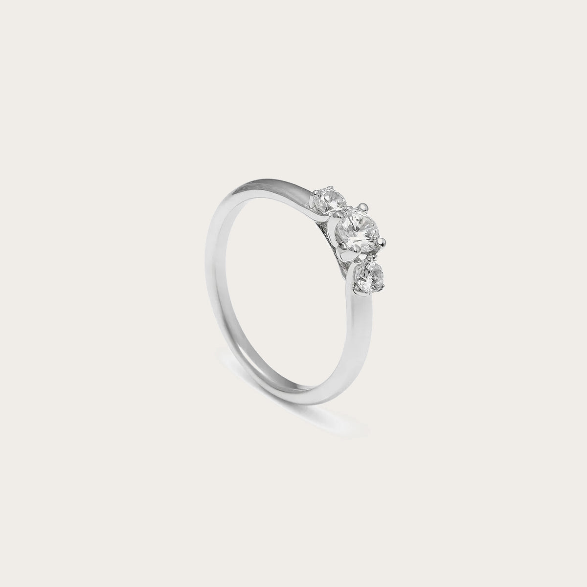 Anillo de compromiso con aro liso. Las garras de la montura enmarcan la piedra central incolora.