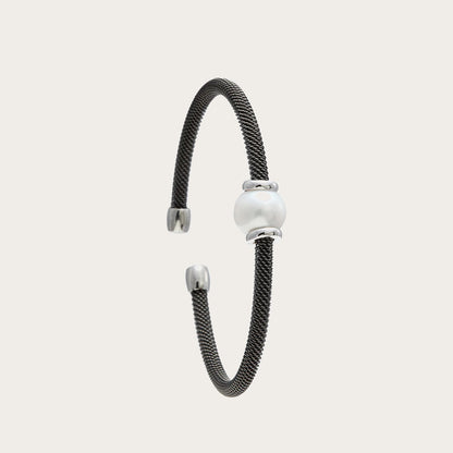 Pulsera de acero y centro claro luminoso. Los detalles luminosos acompañan el motivo redondo de tono nacarado.