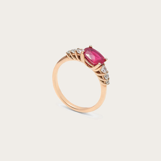 Anillo de centro rosado y hombros de luz. Las garras visibles enmarcan la piedra alargada del frente.