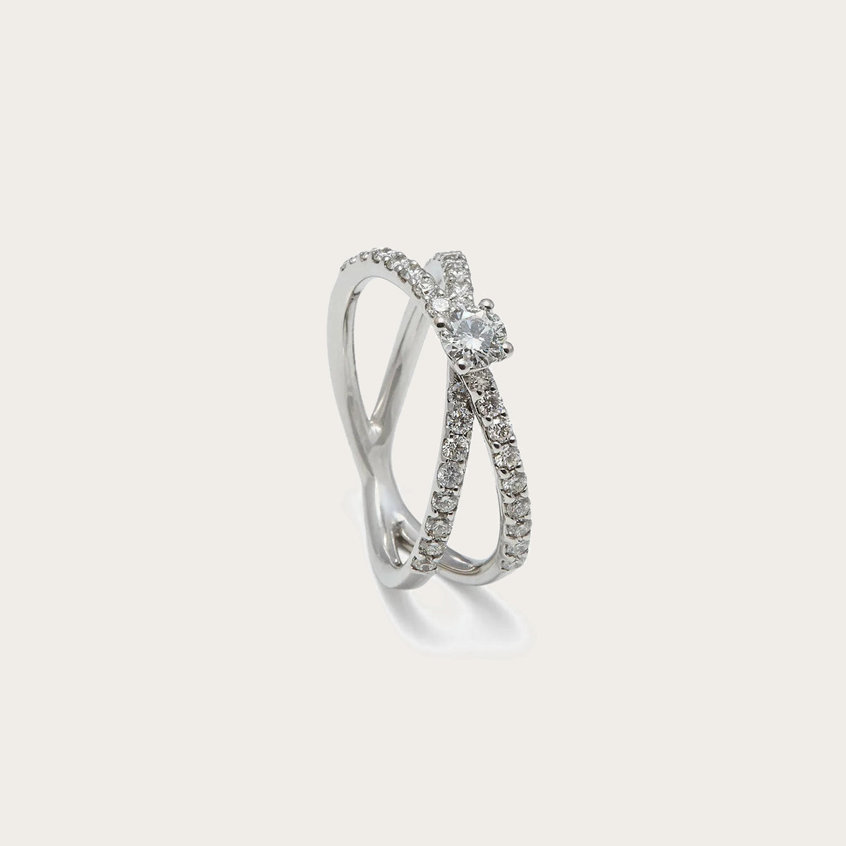 Anillo de compromiso con bandas cruzadas. Una banda lisa se combina con otra recorrida por pequeñas piedras.