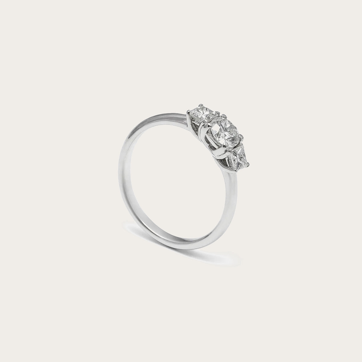 Anillo de compromiso con conjunto central. Las piedras incoloras del frente destacan sobre la banda lisa.