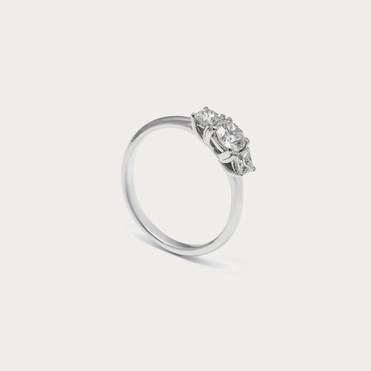 Anillo de compromiso con conjunto central. Las piedras incoloras del frente destacan sobre la banda lisa.