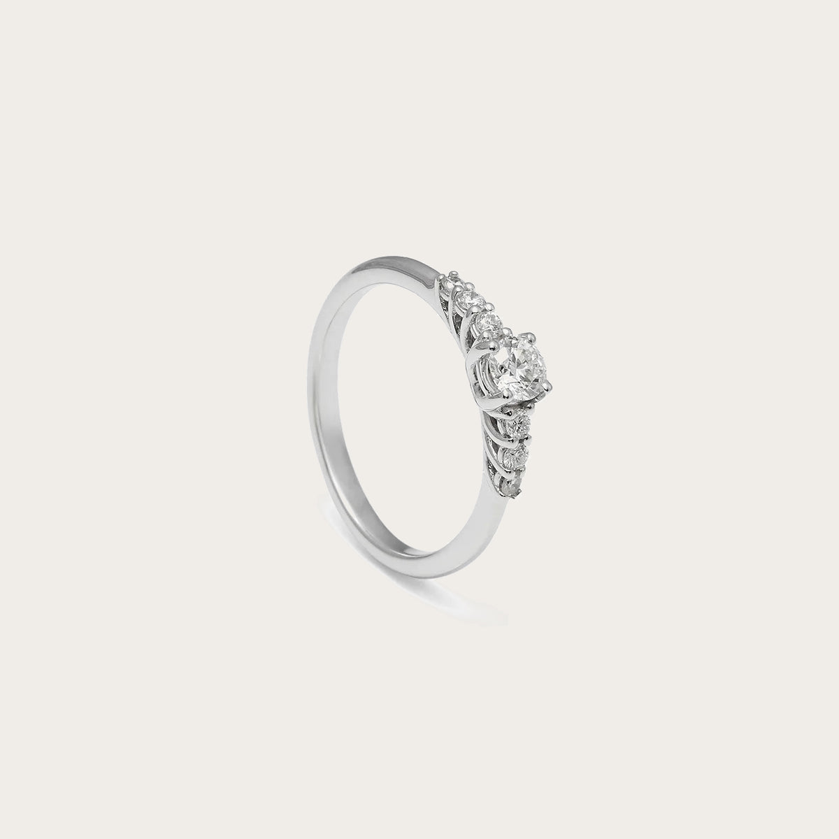 Anillo de compromiso con frente de luz. El centro destacado se acompaña de pequeños detalles luminosos laterales.