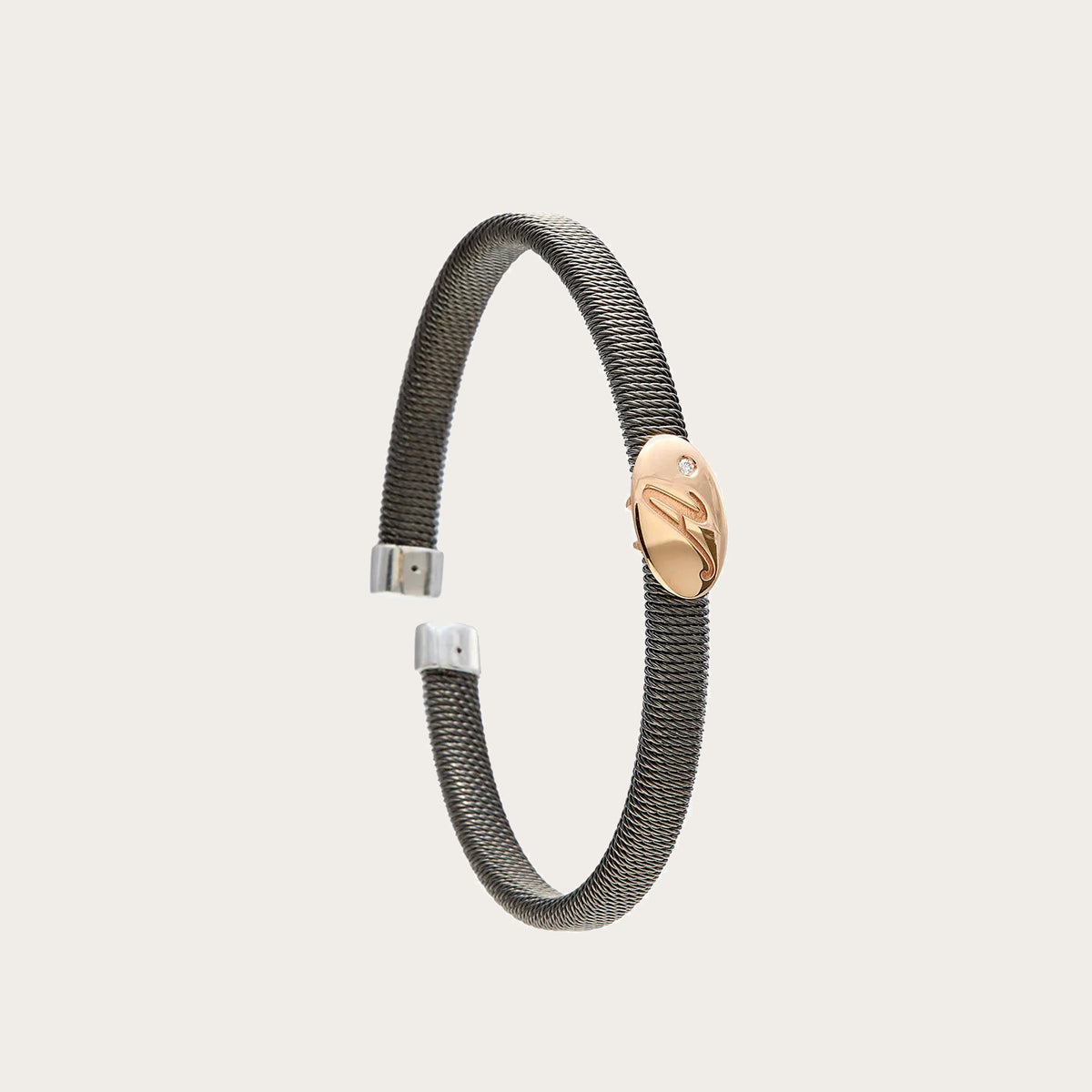 Pulsera de acero con óvalo dorado. El motivo presenta líneas interiores visibles.