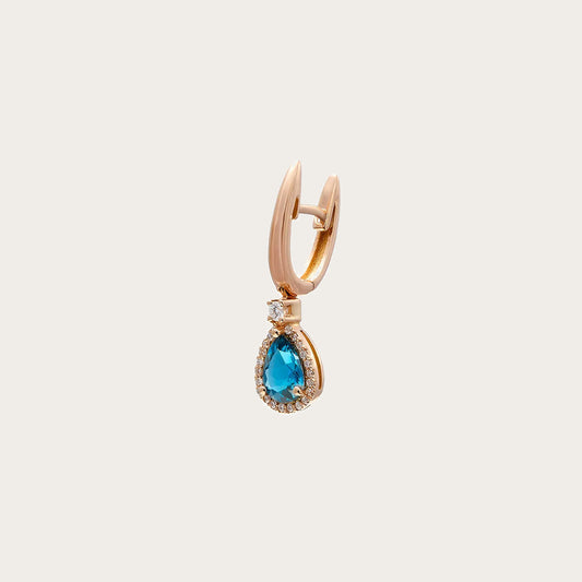 Pendientes de aro dorado y lágrima azul. Un pequeño borde luminoso rodea el centro azul.