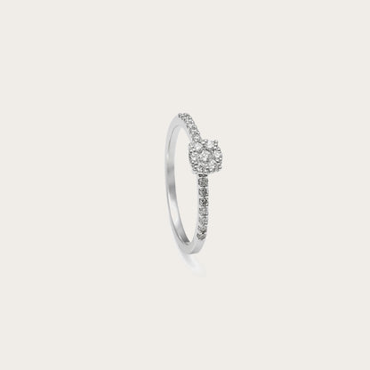 Anillo de compromiso de perfil fino. Las pequeñas piedras del aro conducen hacia la montura central.
