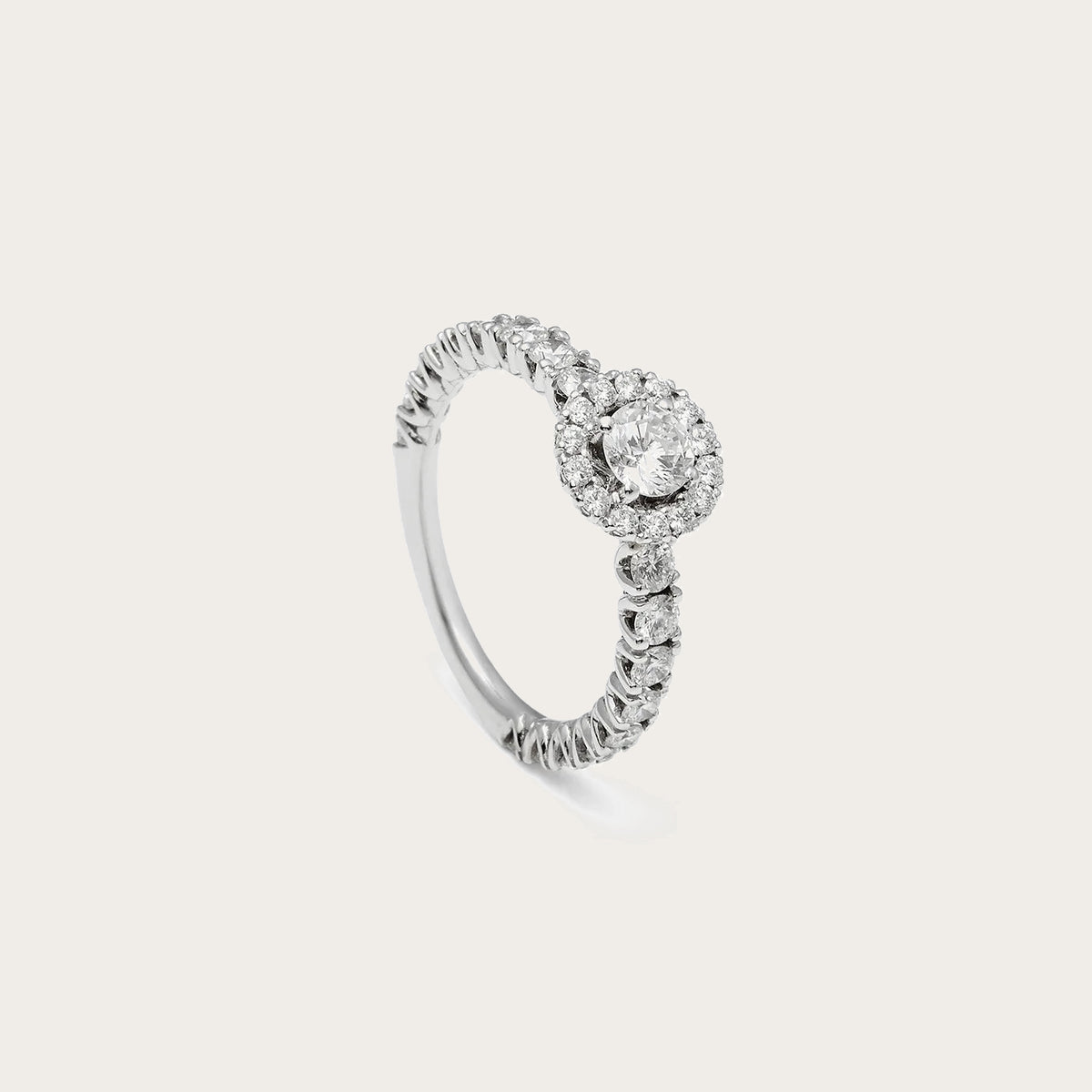 Anillo de compromiso con halo redondo. La composición circular define con claridad el motivo frontal.