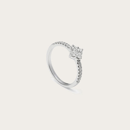 Anillo de compromiso con aro de destellos. La piedra central sobresale sobre una montura de garras visibles.