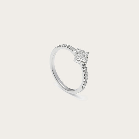 Anillo de compromiso con aro de destellos. La piedra central sobresale sobre una montura de garras visibles.