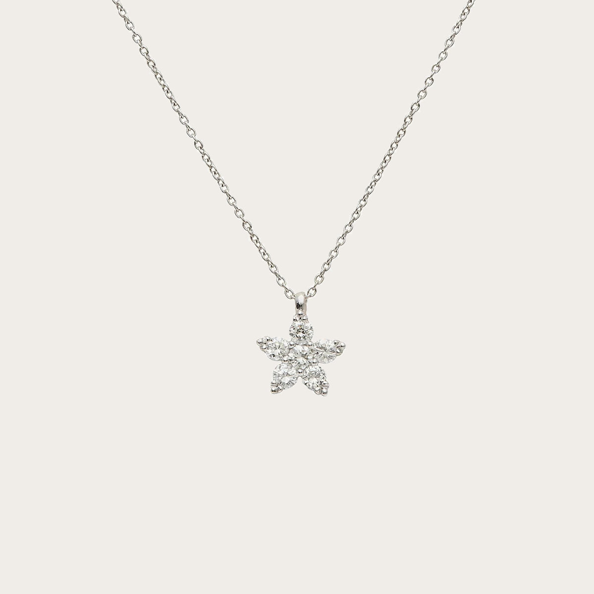 Colgante de estrella luminosa. Las piedras incoloras recorren las puntas del motivo.