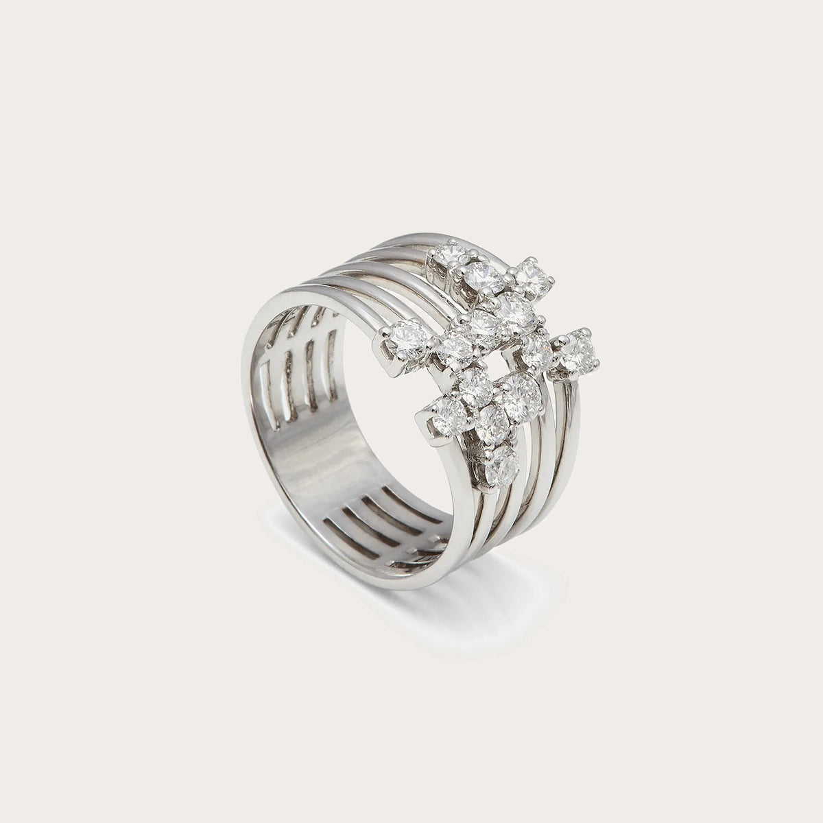 Anillo de bandas con centros agrupados. El tono plateado une las monturas con los aros laterales.