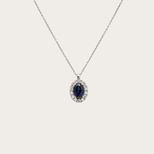 Colgante oval azul con halo. Las pequeñas piedras incoloras siguen el contorno de la piedra principal.
