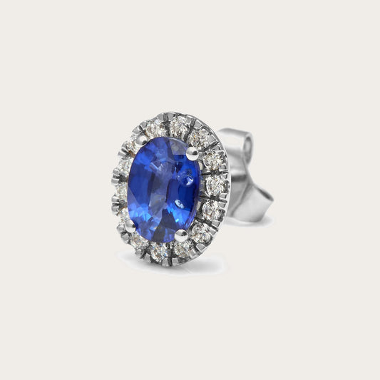 Pendientes de centro azul oval y halo. Las piedras incoloras del contorno se presentan en monturas visibles.