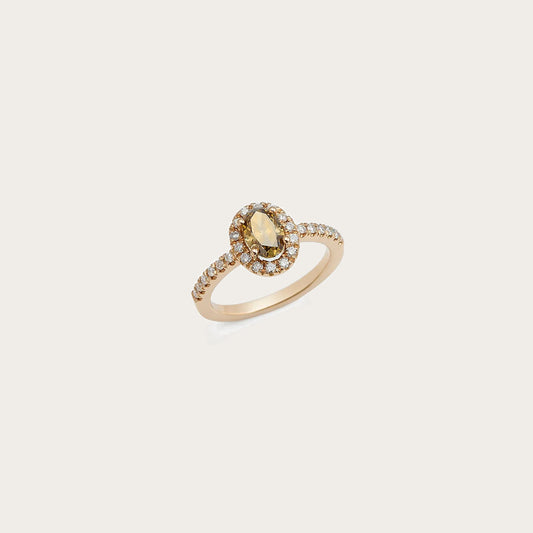 Anillo de centro cálido y halo de luz. La piedra ovalada ocupa el centro de una orla de pequeños destellos.