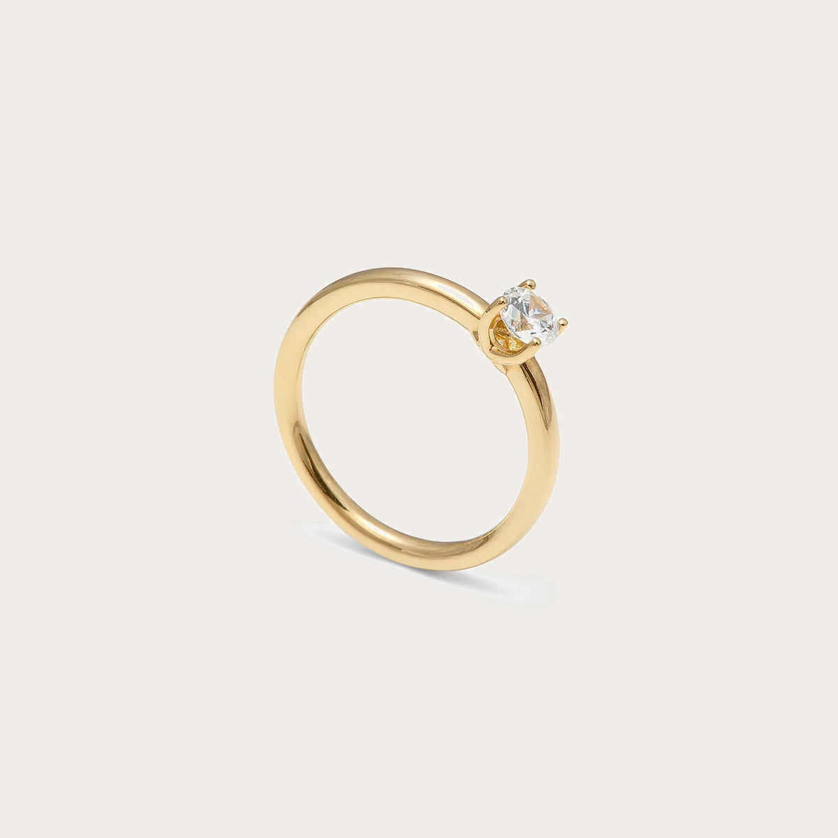 Solitario de tono dorado y centro de luz. La montura central presenta garras visibles de contorno curvo.