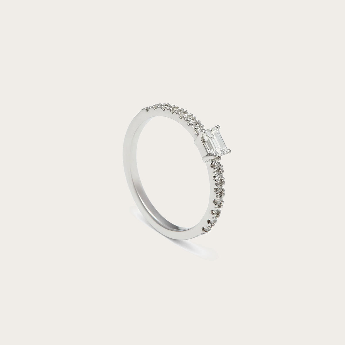 Anillo de compromiso con centro rectangular. Las garras visibles enmarcan las esquinas del motivo central.