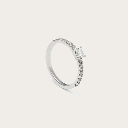 Anillo de compromiso con centro rectangular. Las garras visibles enmarcan las esquinas del motivo central.