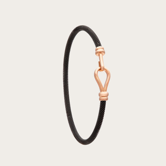 Pulsera de acero y oro con motivo abierto. El detalle central dibuja un contorno alargado con espacio interior.