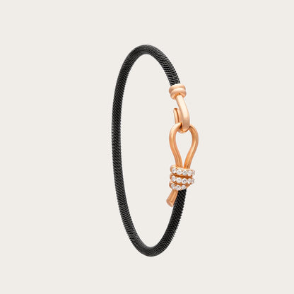 Pulsera de acero y oro con curva y destellos. Los trazos del motivo central dejan un espacio abierto.