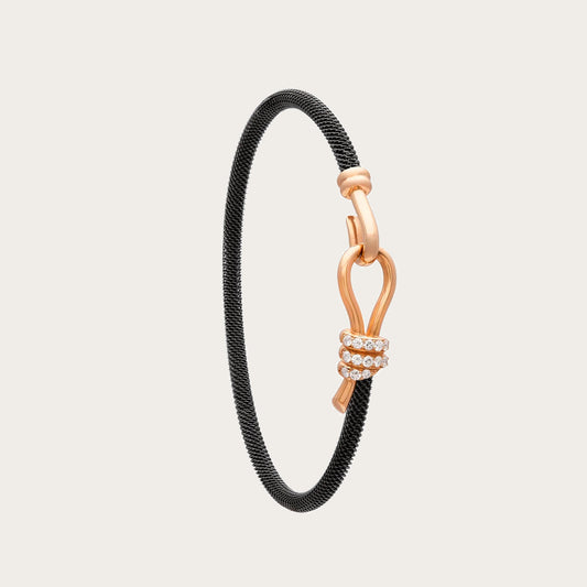 Pulsera de acero y oro con curva y destellos. Los trazos del motivo central dejan un espacio abierto.