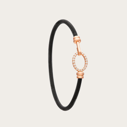 Pulsera de acero y oro con óvalo de luz. El motivo central conserva un espacio interior abierto.