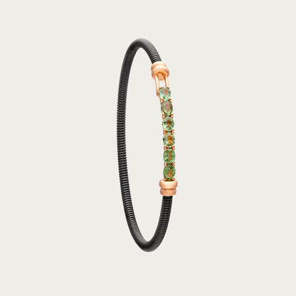 Pulsera de acero y oro con zafiros verdes. Las pequeñas monturas siguen una línea alargada.